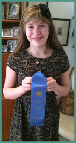 At home with her blue ribbon. Nervous at first, she came home so proud of accomplishment.