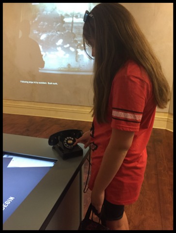 "Mama, what IS this thing, and how did it work? Audrey ponders the rotary phone at an interactive display.