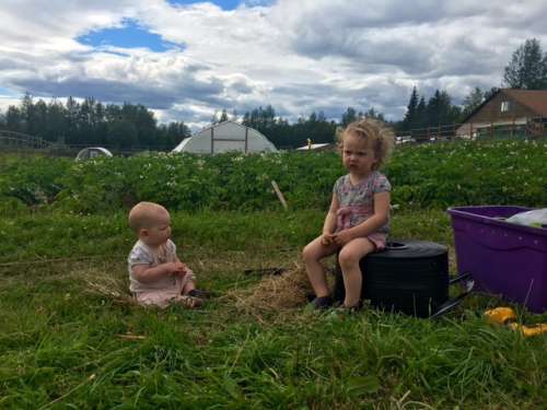 Big Sister Ava taking time out of her busy schedule to tell Opal a story while I play with irrigation lines.