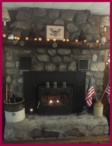 Pine cone string lights, vintage Americana and flags, and candlelight make my friend's lake house fireplace summer cozy.