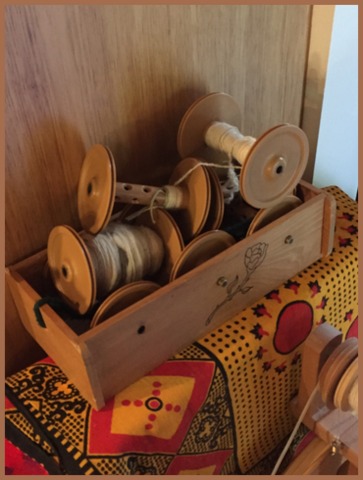 June's Lazy Kate sits with  various bobbins that go with her "Rose" spinning wheel.