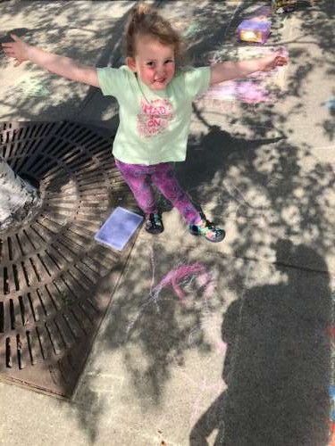 Showing off sidewalk chalk art at a block party in town