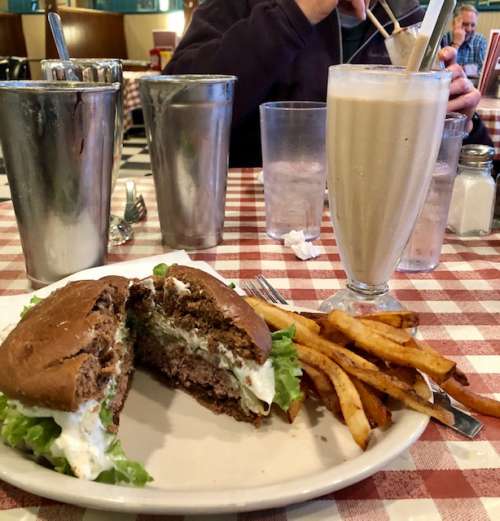 I am definitely not a food stylist...this is a plaza burger from convention grill in Minneapolis--it has sour cream and diced onions on a rye bun.  Inspired by a restaurant in my college town! Paired with a chocolate malt and fries.  American as it gets.