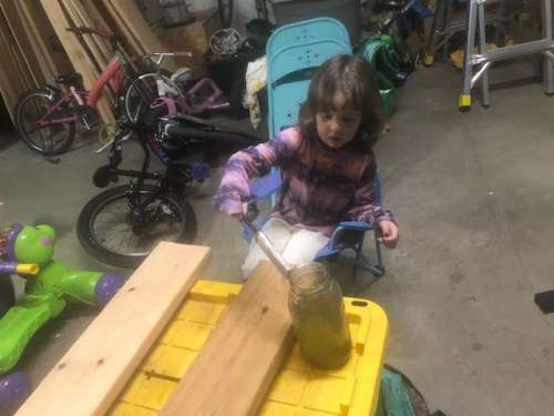 Ava helping stain future shelves with our homemade stain.