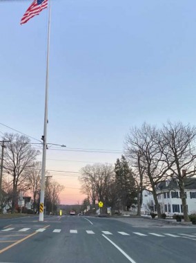 Our town’s historic Main Street and flagpole against a pink early spring sky