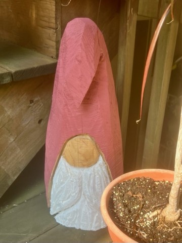 My local-artisan-made, chainsaw sculpted gnome peers from behind a potted plant near my porch walkers. He makes us smile. 